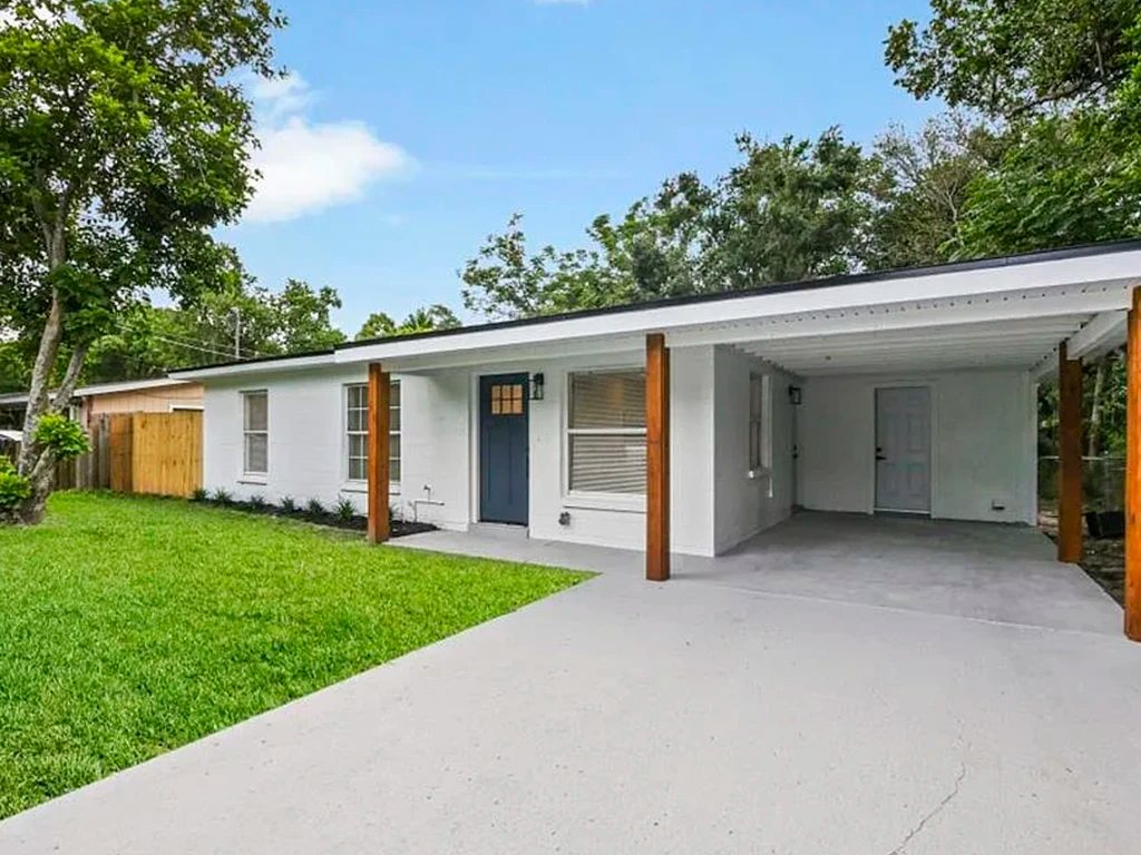 After: white exterior, blue door and rebuilt carport